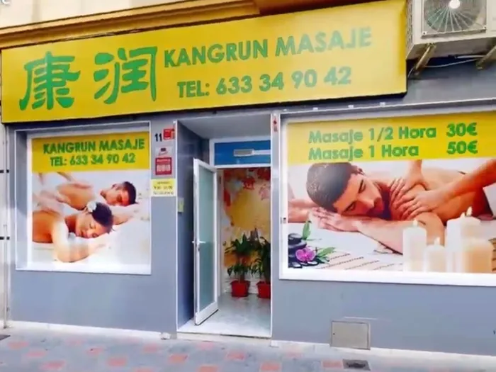 El escaparate de Kangrun Masaje con el cartel amarillo y los precios
